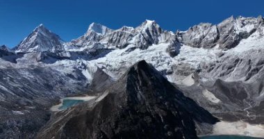 Açık mavi gökyüzünün altında karlı dağlar