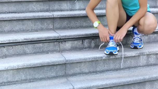 Спортивная бегунья завязывающая шнурки — стоковое видео
