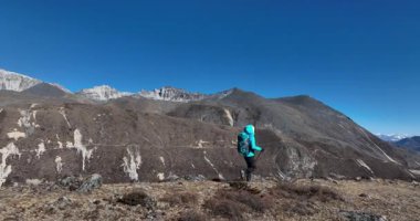 Sırt çantalı bir kadın yüksek irtifada dağ yürüyüşü yapıyor.
