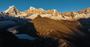 Tibet, Çin 'deki güzel kar örtülü dağların ve göl manzarasının hava görüntüleri.