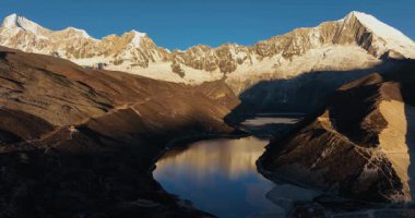 Tibet, Çin 'deki güzel kar örtülü dağların ve göl manzarasının hava görüntüleri.