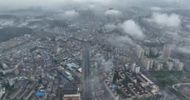 Bulutlarla kaplı şehir manzarasının havadan görüntüsü