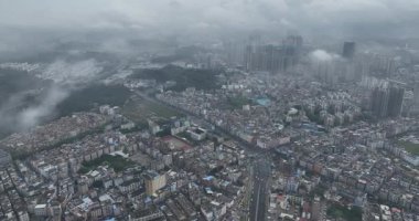 Bulutlu gökyüzünün altındaki şehir manzarasının havadan görüntüsü