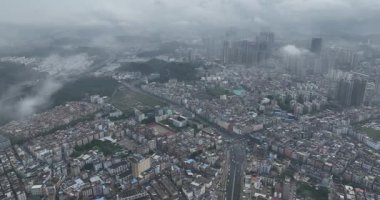 Bulutlu gökyüzünün altındaki şehir manzarasının havadan görüntüsü