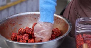 Kavanozda kırmızı baharatlı küpleri karıştırıyorum.