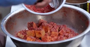 Kavanozda doğranmış sebzelerin üzerine baharat dökülüyor.