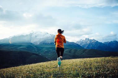 Çimenli tarlalarda koşan kişi