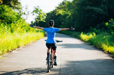 Kollarını açmış bisiklet sürmekten hoşlanan biri.
