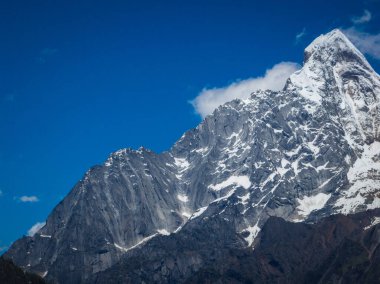 Karlı dağ zirvesi berrak mavi gökyüzüne karşı
