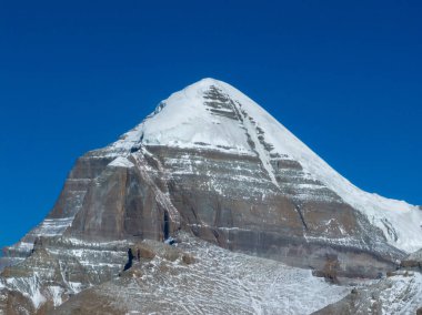 Karlı dağ zirvesi berrak mavi gökyüzüne karşı