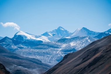 Açık mavi gökyüzünün altında karlı dağlar