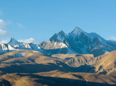Açık mavi gökyüzünün altında karlı dağlar