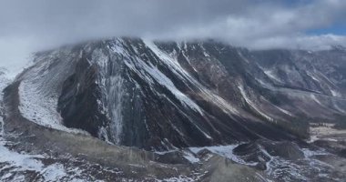 Bulutlu gökyüzü altında karlı dağlar