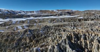 Eşsiz oluşumları ve dağları olan kayalık bir manzara.