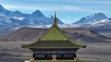 Karlı dağlara karşı süslü tapınak çatısı