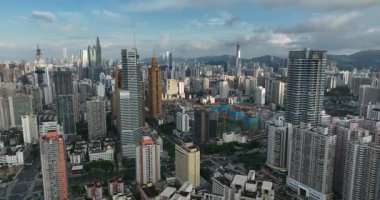 Yüksek binalar ve bulutların yer aldığı şehir silüeti