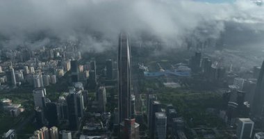 Bulutlu gökdelenle çevrili uzun gökdelen