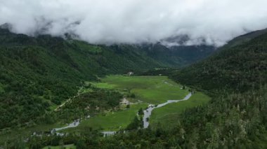Puslu dağlarla çevrili yemyeşil bir vadi.