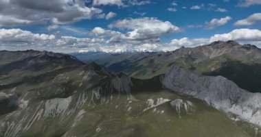 Bulutlu mavi gökyüzünün altında engin dağlar