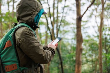 Ormanda cep telefonu kullanan bir kadın.