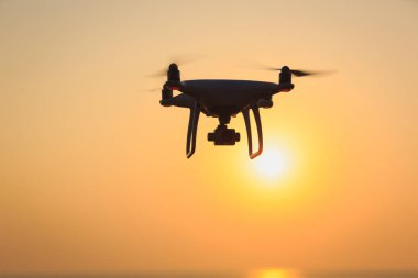 İHA deniz kıyısında havada uçuyor.