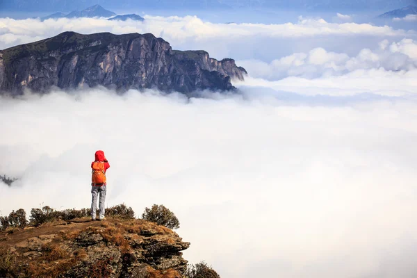 Kvinnan vandrare tar foto på berg — Stockfoto