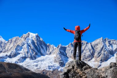 Sırt çantalı bir kadın yüksek irtifada dağ yürüyüşü yapıyor.