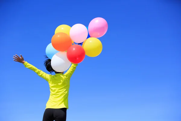 Ung kvinna med färgglada ballonger — Stockfoto