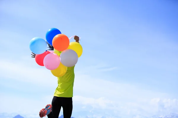 Jonge vrouw met kleurrijke ballonnen — Stockfoto