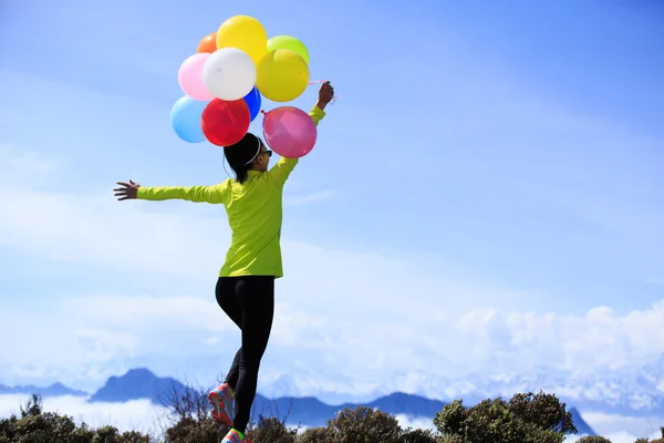 Junge Frau mit bunten Luftballons — Stockfoto