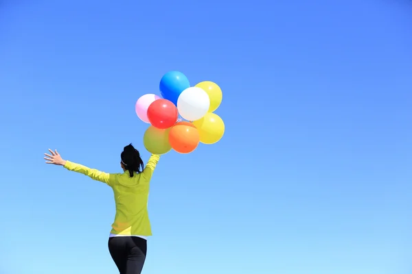 Cheering woman with colorful balloons — Stock Photo, Image
