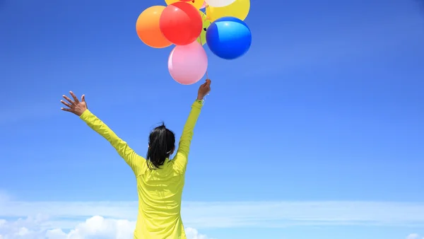 Jubelnde Frau mit bunten Luftballons — Stockfoto