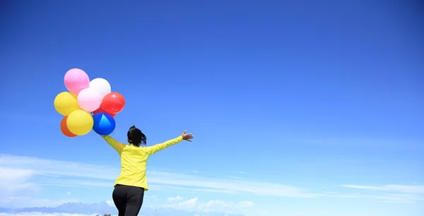 Jubelnde Frau mit bunten Luftballons — Stockfoto