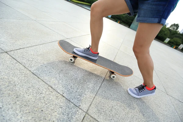 Kvinnliga skateboardåkare ben — Stockfoto