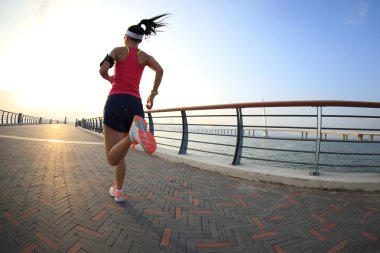 fitness woman running at seaside clipart