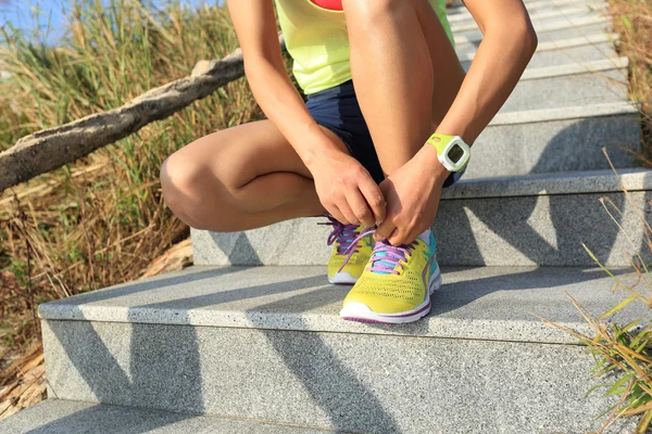 Woman runner tying shoelaces — Stock Photo, Image