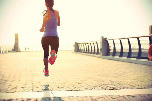 Fitness mujer corriendo a la orilla del mar — Foto de Stock