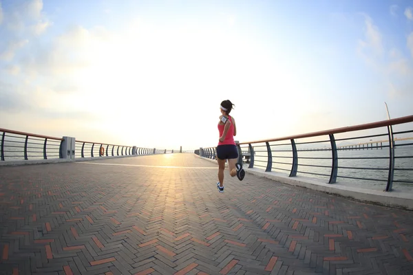 Fitness mujer corriendo a la orilla del mar — Foto de Stock