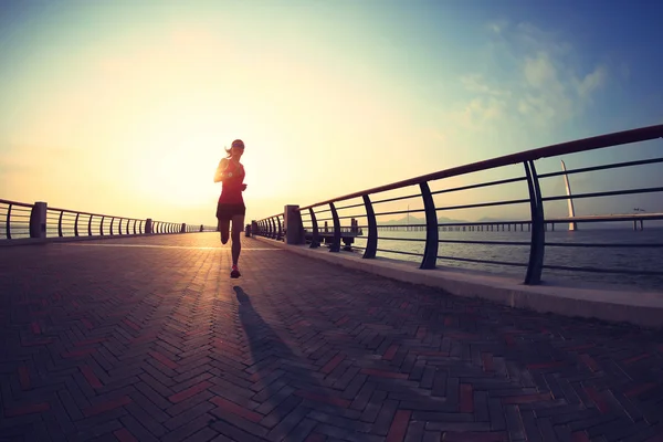 Mulher fitness correndo à beira-mar — Fotografia de Stock