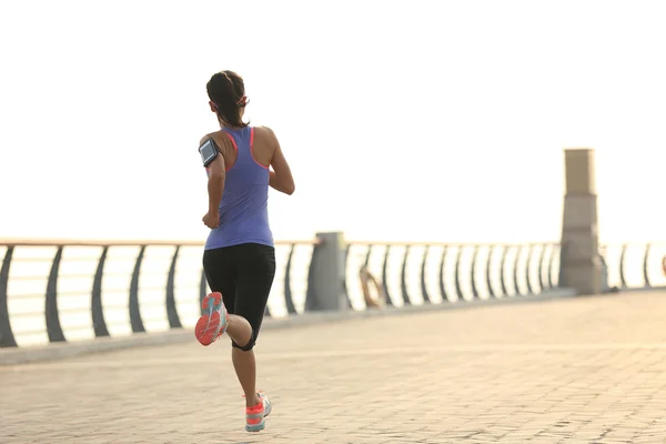 Fitness-Frau läuft am Meer — Stockfoto