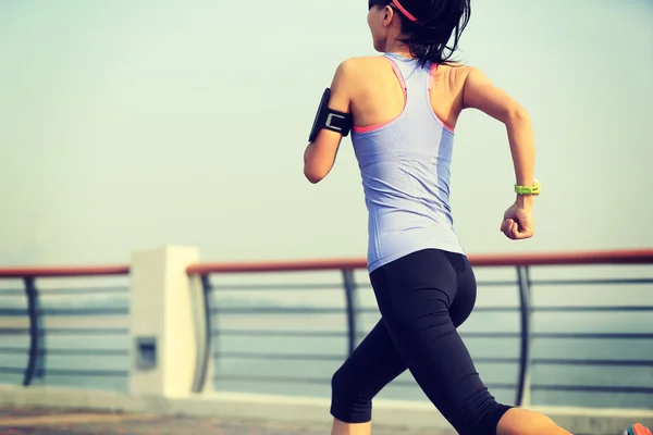 Fitness mujer corriendo a la orilla del mar — Foto de Stock