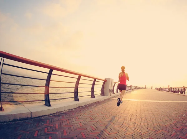 Fitness mujer corriendo a la orilla del mar —  Fotos de Stock