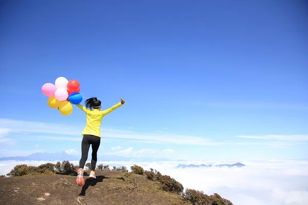 Junge Frau mit bunten Luftballons — Stockfoto