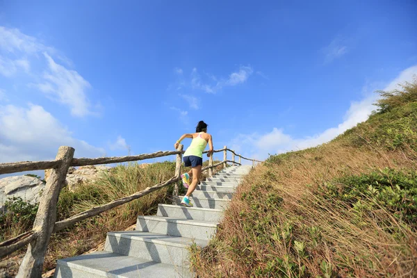 Женщина бежит вверх по каменной лестнице — стоковое фото