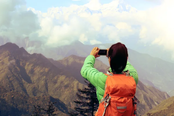 Woman with smartphone on mountain peak — Stock Photo, Image