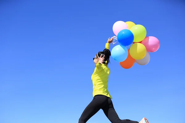 Молодая женщина с цветными воздушными шарами — стоковое фото