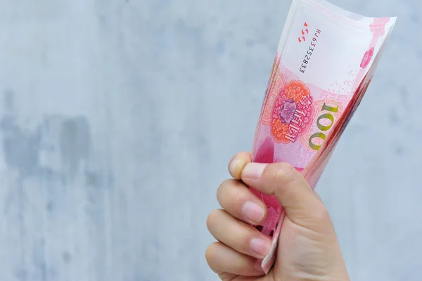 Рука с юанями — стоковое фото