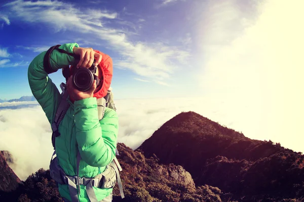 Jovem fotógrafo mulher no pico da montanha — Fotografia de Stock