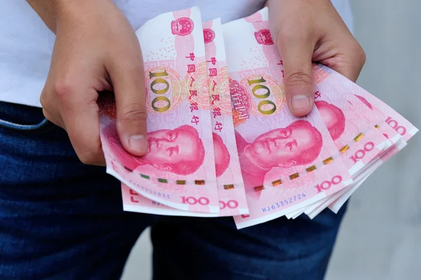 Yuan para faturaları ile el — Stok fotoğraf