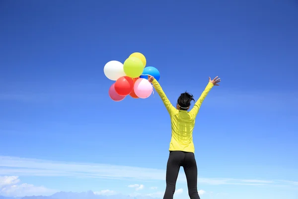 Juichende vrouw met kleurrijke ballonnen — Stockfoto